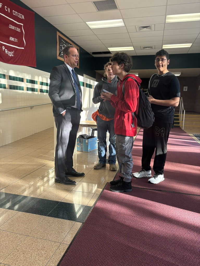 a picture of a prinipal talking to students in the hallway