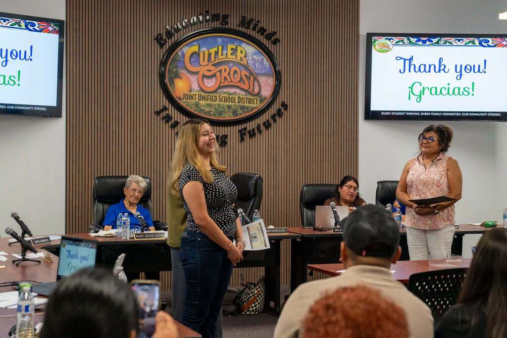 teacher smiles as she is recognized