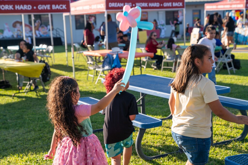 Little girl holds her flower balloon art at the Cutler School carnival