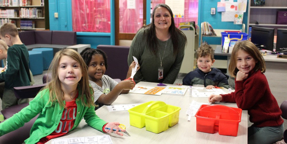 Students with teacher at table. 