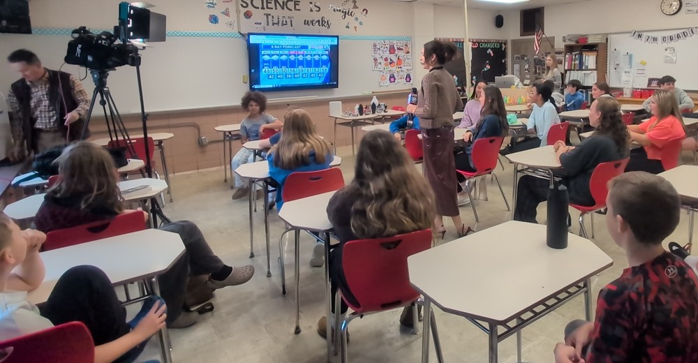 Fox8 Meteorologist gives student a lesson about weather.