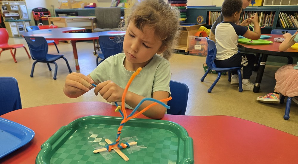 Pre-K strudent working at a table.