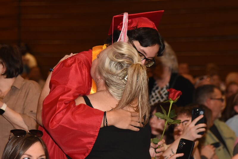 Students presents rose to family member. 