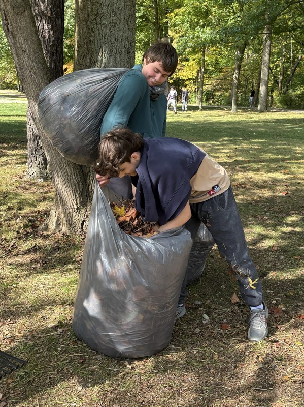 Students bag raked leaves.