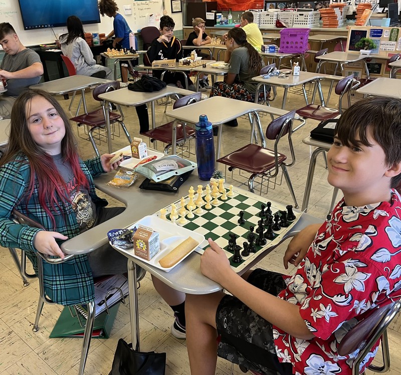 A boy and girl play chess.