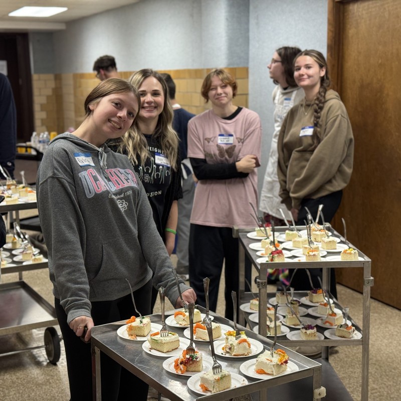 Student volunteers serving cake.
