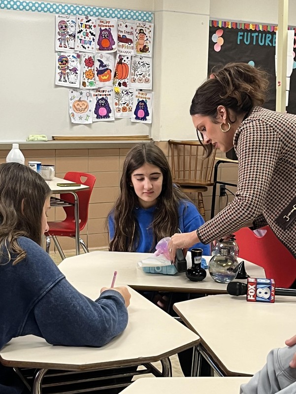 Dahlia Castillo and Lylah Beno watch as Walter pours an agent onto the ice.
