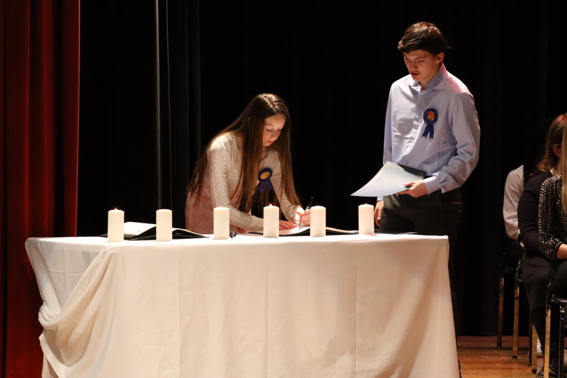 NJHS inductees Olivia Gindlesperger signs the register while inductee Julian Gwynn awaits his turn.&nbsp;