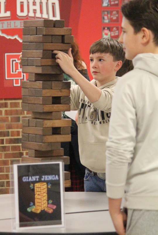 Students try to keep Jenga tower from falilng.