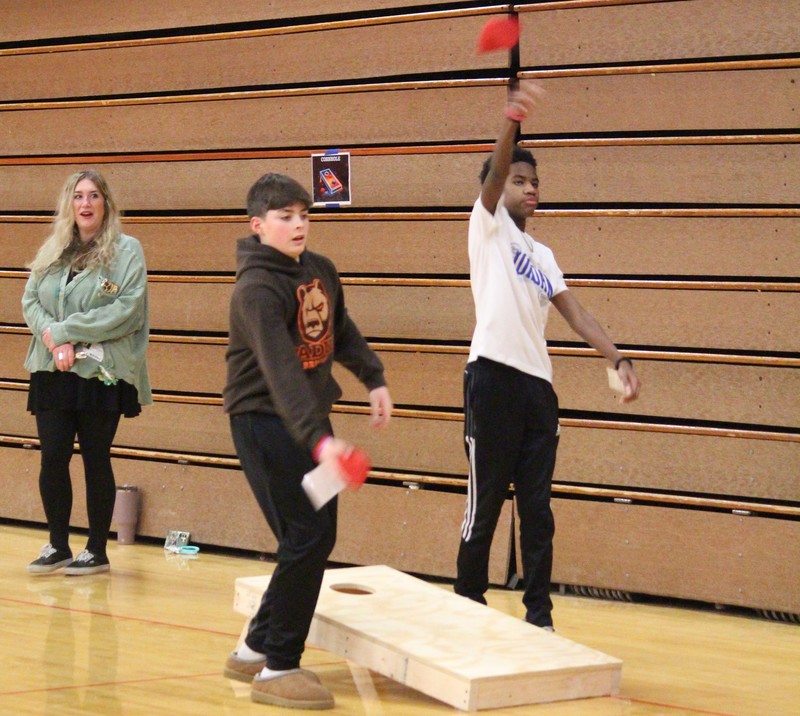 Students play Corn Hole in the gymnasium.