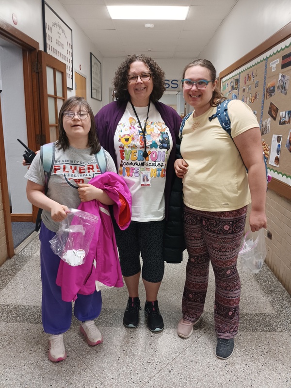 Secretary to the Director of Athletics and Acvities Joellen Podoll (center) greets helps students pass out stickers. 