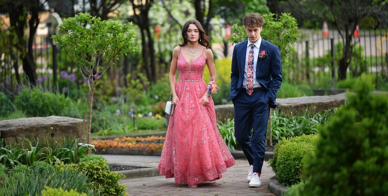 Prom Goers stroll garden. 