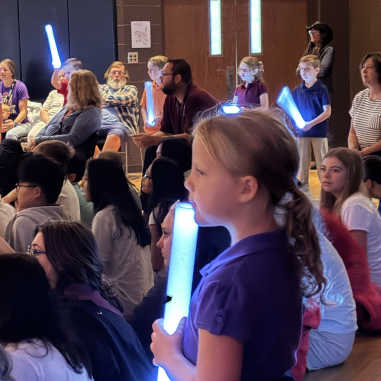 first grade student demonstrating shining God‘s light with a glow stick