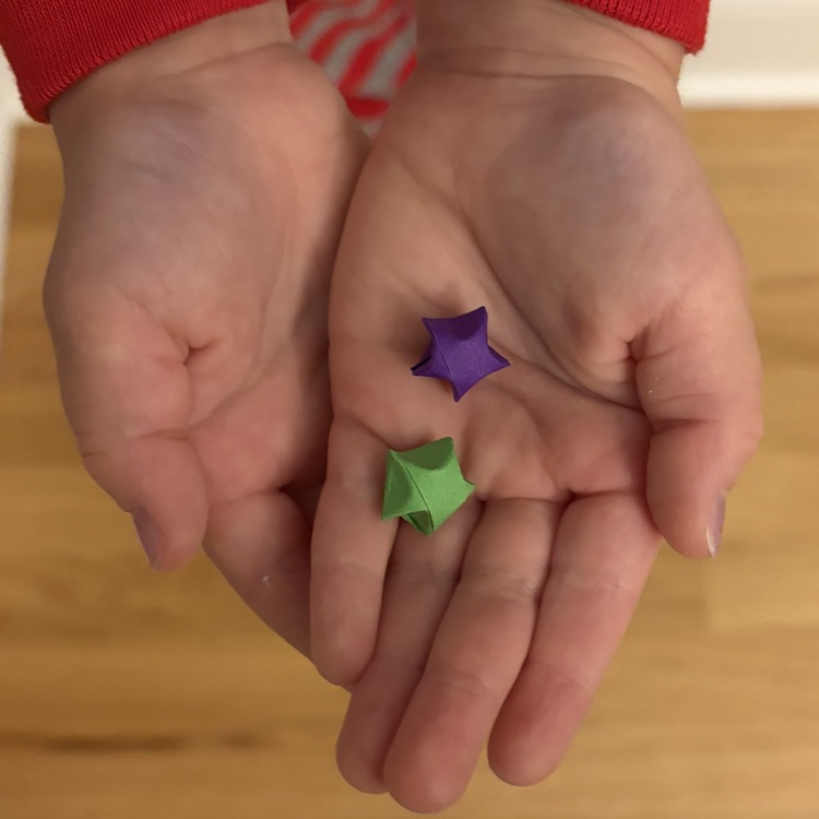 student holding two paper stars