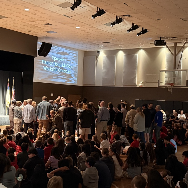 students and staff praying over pastors