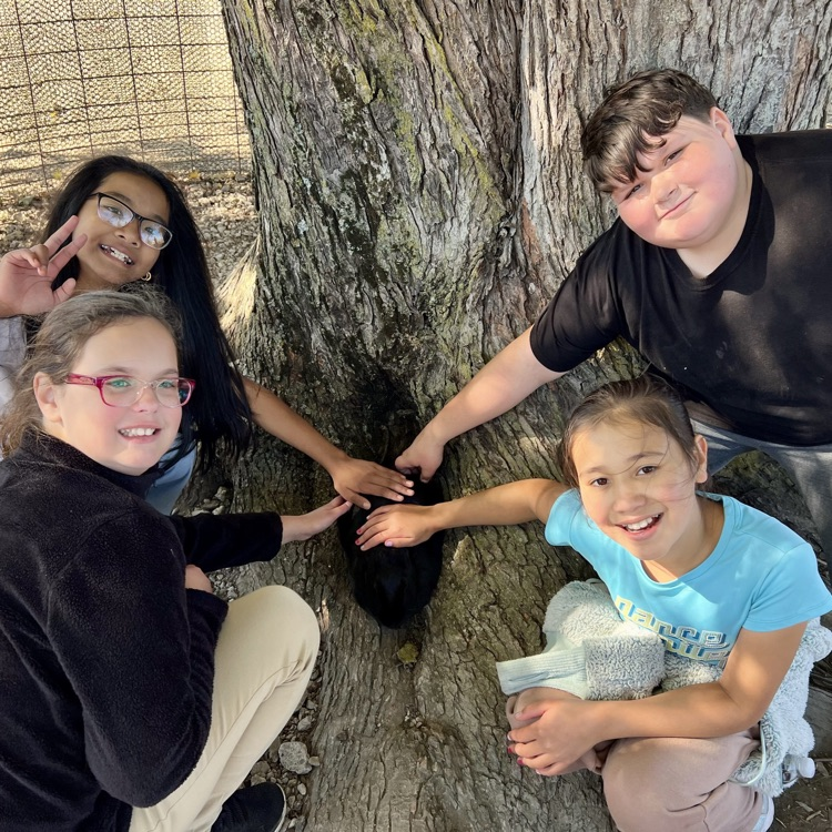 fifth graders, smiling at the camera on a field trip