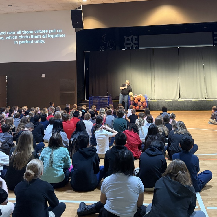 Miss Fravel using carts of basketballs and volleyballs for the lesson