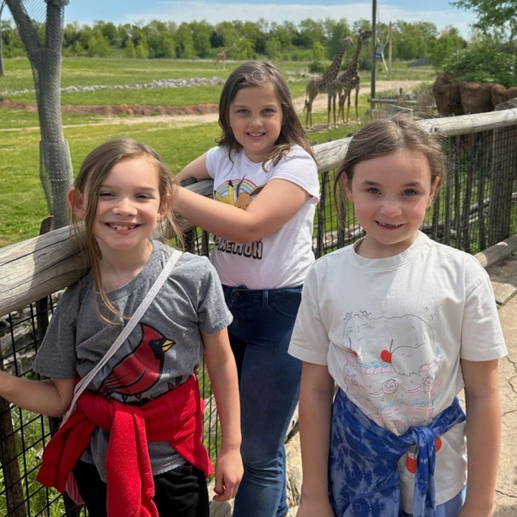 Second grade students posing by the giraffes