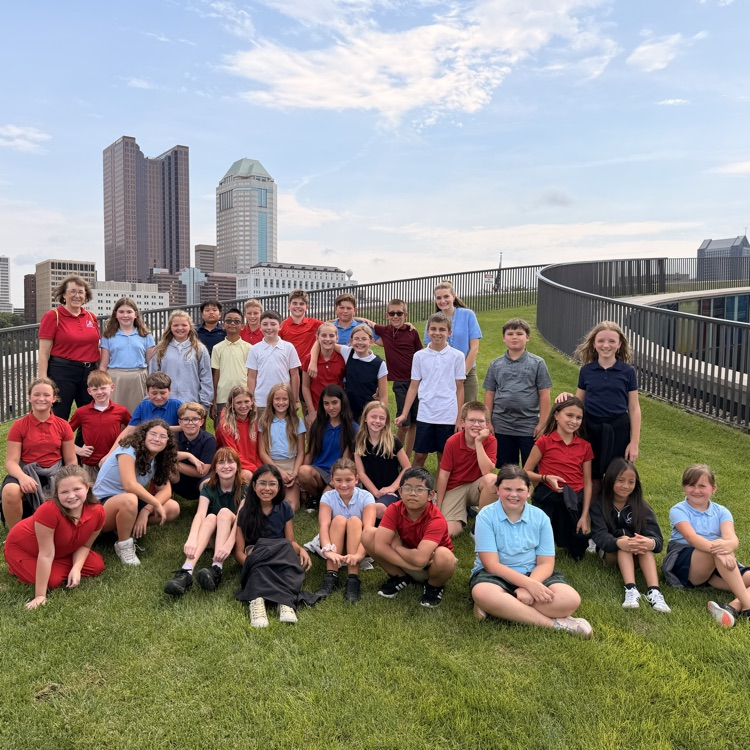 group photo of 5th graders and their teachers on the grassy lawn outside