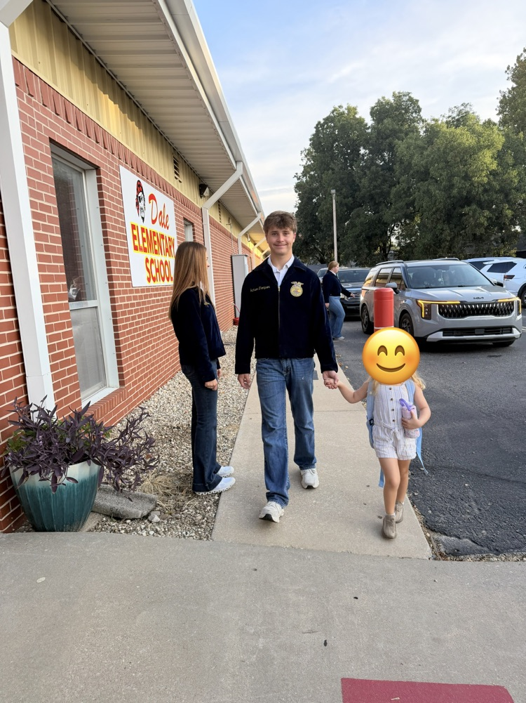 HS helper helping an elementary student during morning car line. 