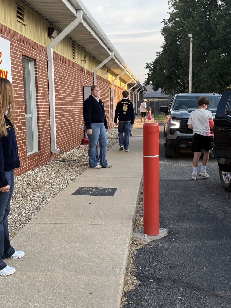HS helper helping an elementary student during morning car line. 
