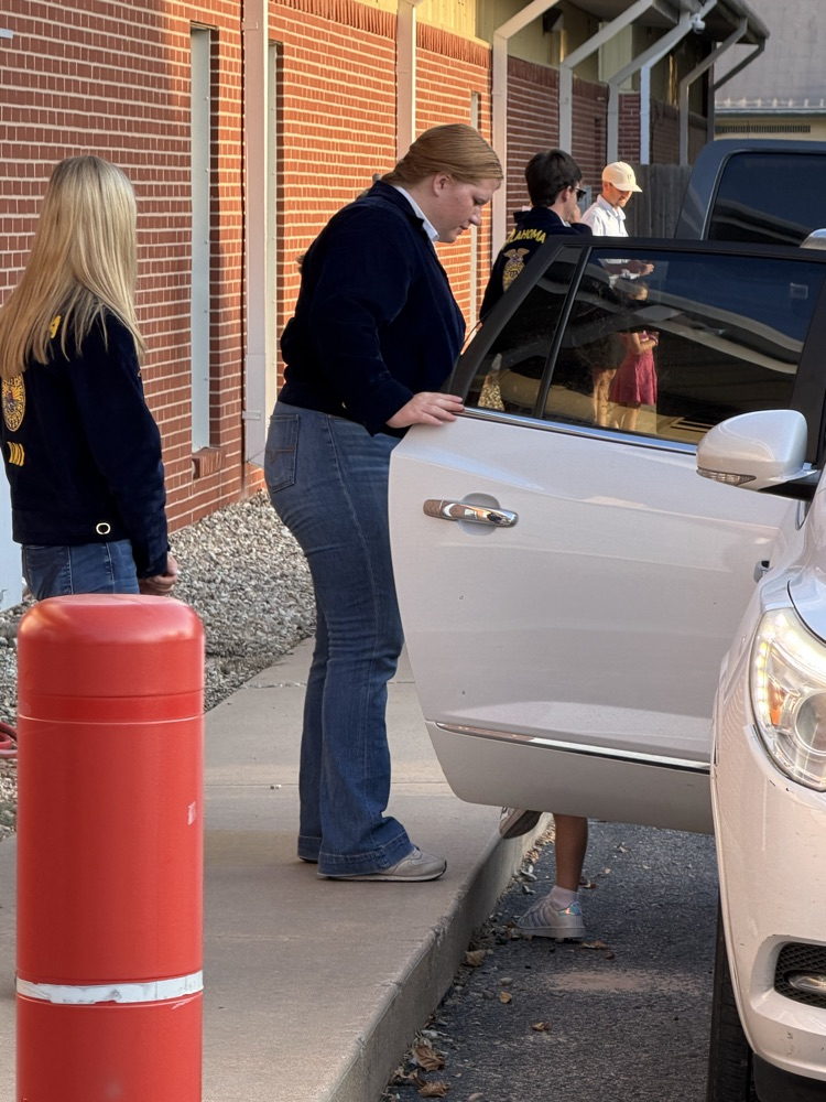 HS helper helping an elementary student during morning car line. 