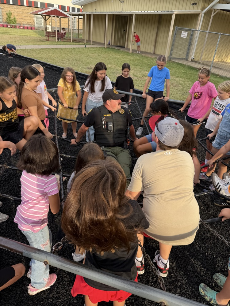 SRO playing on the playground with elementary students. 