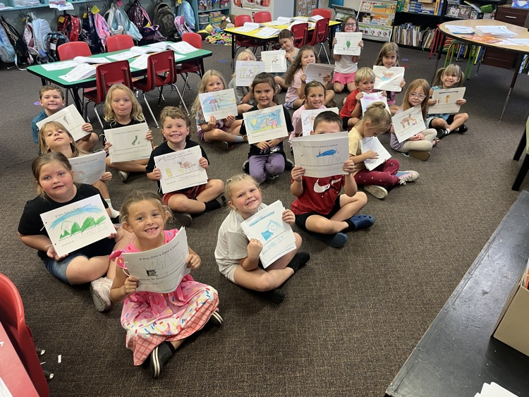 Students hold up books.