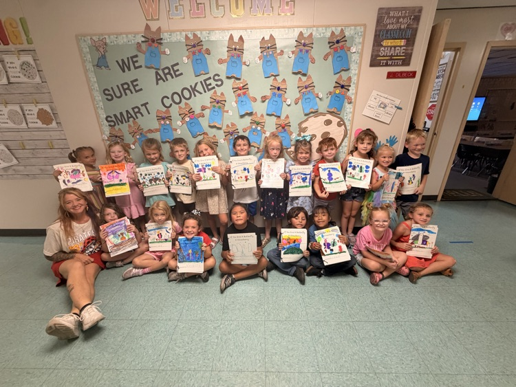Students hold up books.