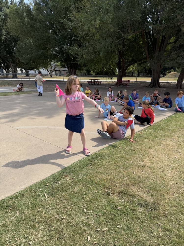 students flying paper airplanes
