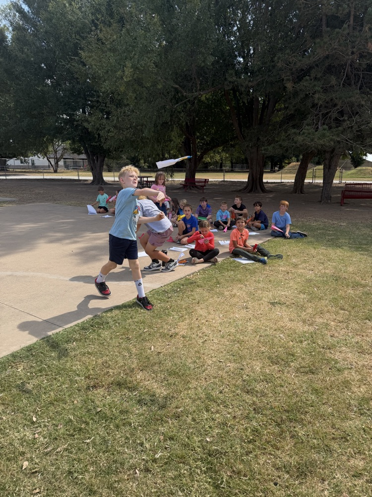students flying paper airplanes