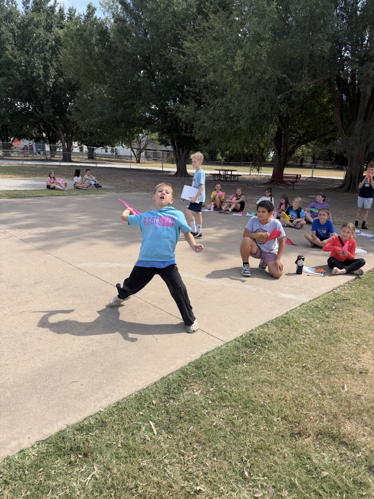 students flying paper airplanes