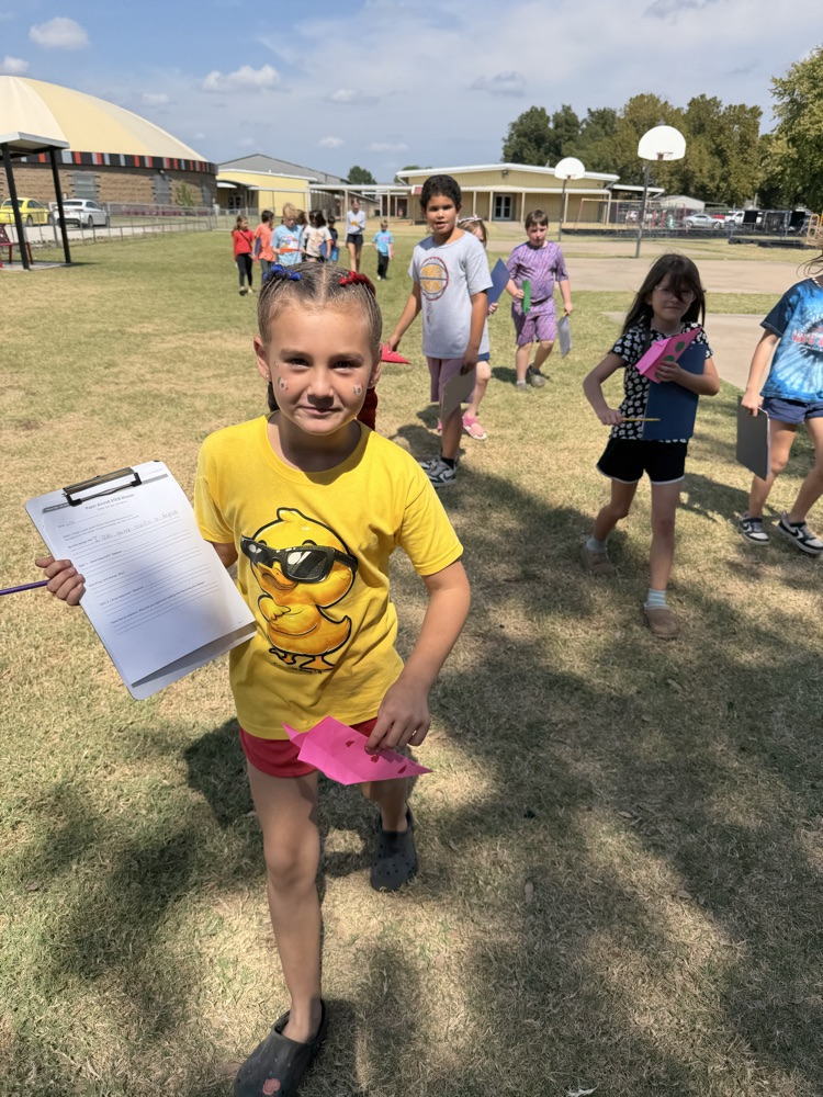 students flying paper airplanes
