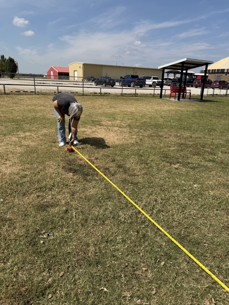 A teacher using a tape measure.