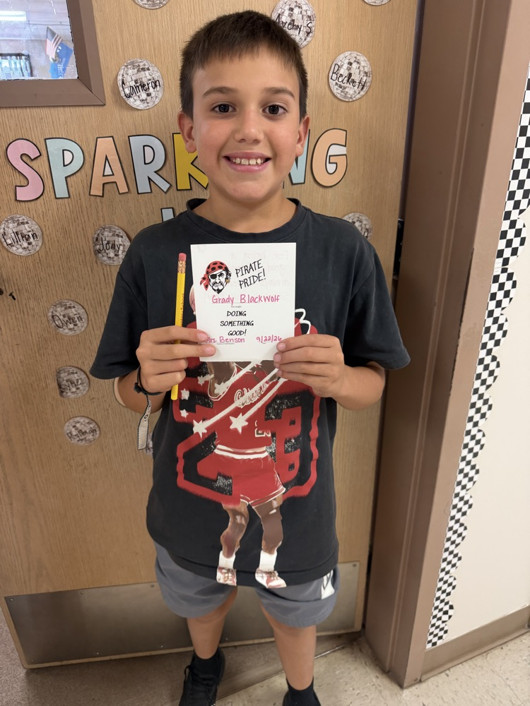 4th grade student holding up a pirate pride award