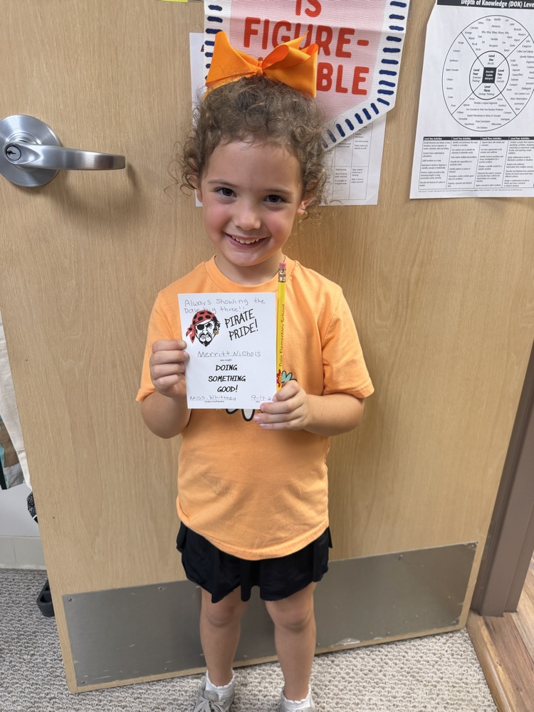 kindergarten student holding up a pirate pride award