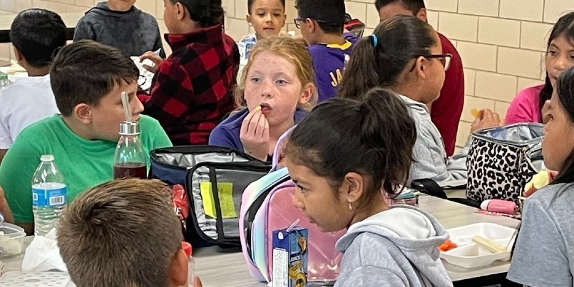 Photo: photo of 4th grade students catching up with friend at lunch time.