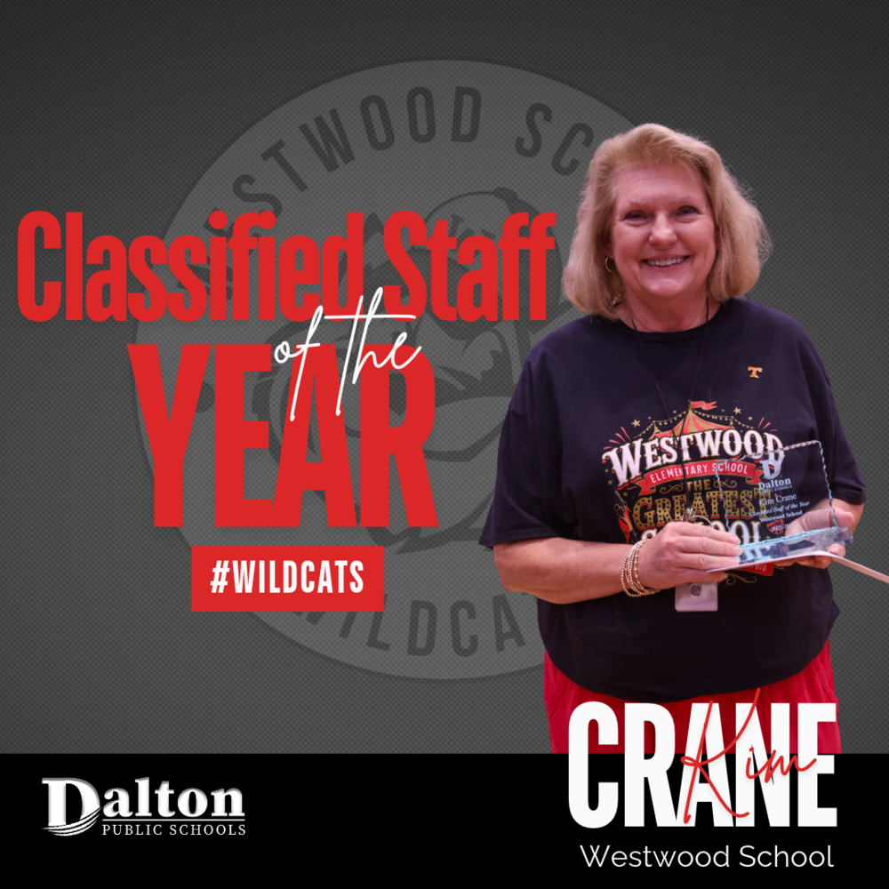 A square staff recognition graphic featuring Kim Crane holding an acrylic award plaque while smiling against a dark grey background overlaid with a faded Westwood School Wildcats logo.