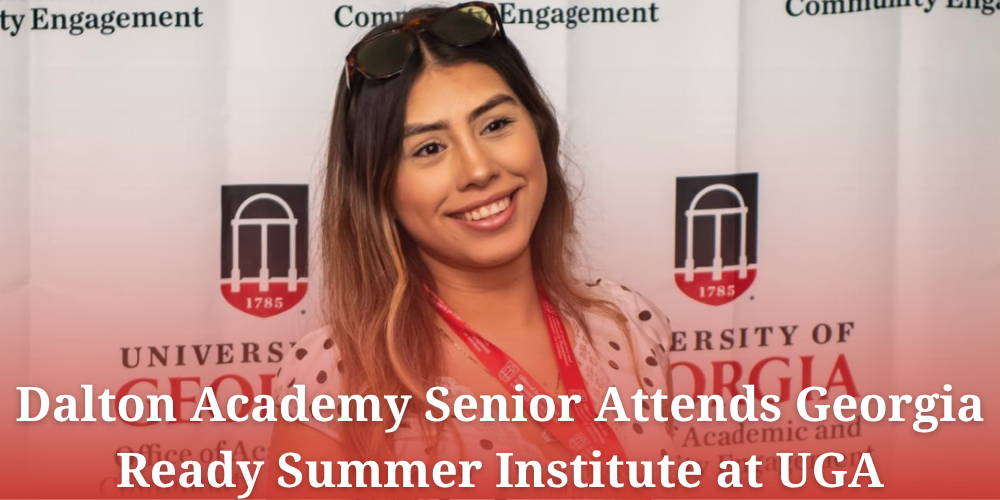 A news announcement graphic titled "Dalton Academy Senior Attends Georgia Ready Summer Institute at UGA" overlaying the image in white bold text. The photo features a smiling young woman with highlighted hair and sunglasses resting on her head, wearing a red lanyard over a polka-dot shirt. In the background is a University of Georgia (UGA) backdrop showing the arch crest and "Community Engagement" branding.