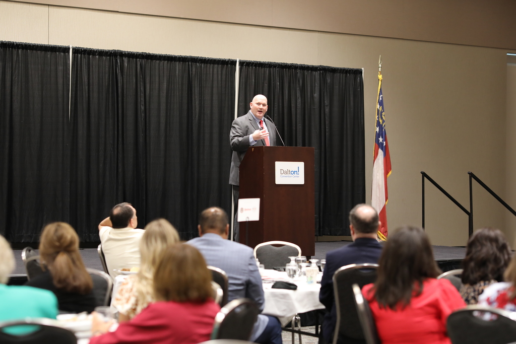 Dr. Craft speaks to a crowd while standing behind a podium