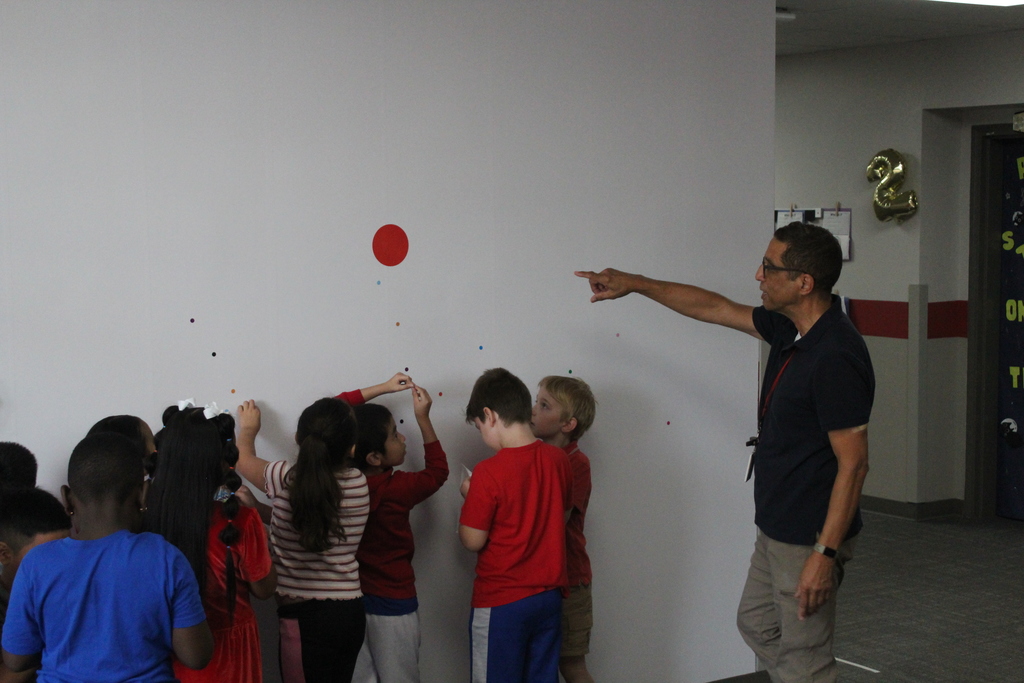 Students placing dots on wall 