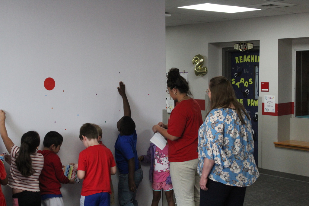Students placing dots on wall 