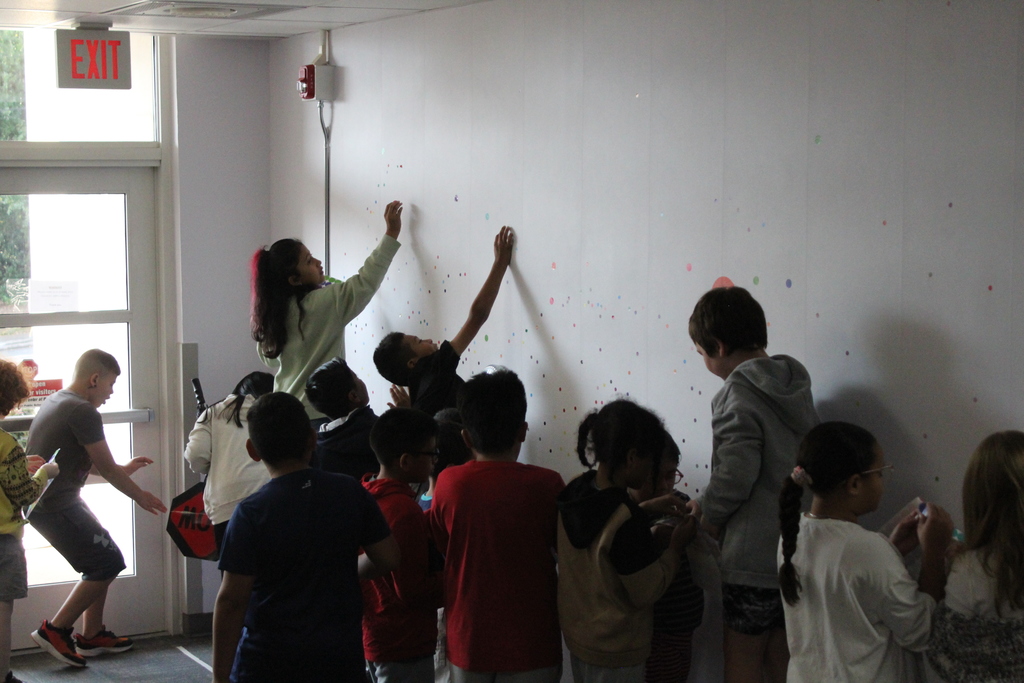 Students placing dots on wall 
