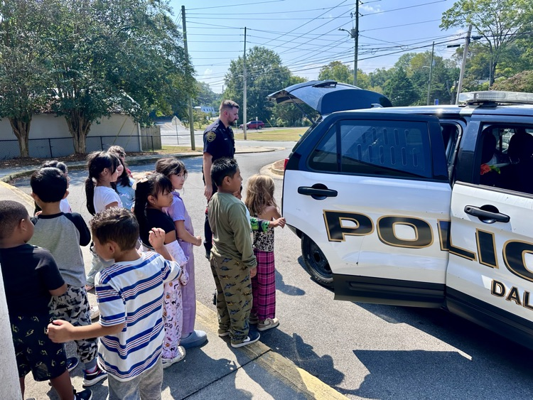 Officer Warren showing his police car to the students 