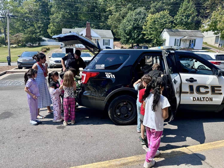 students looking at Officer Warren’s police car 