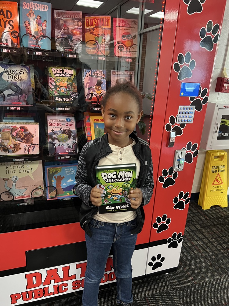 Student getting a book from the Book Vending Machine as a reward