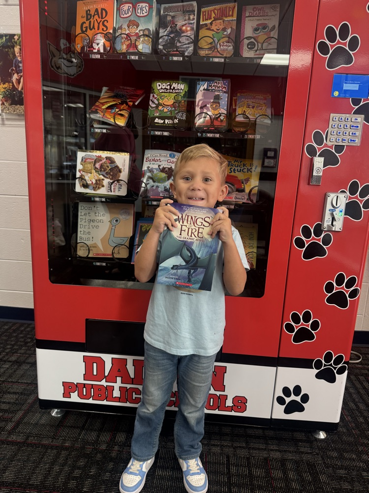Julian showing the book he got from the vending machine 