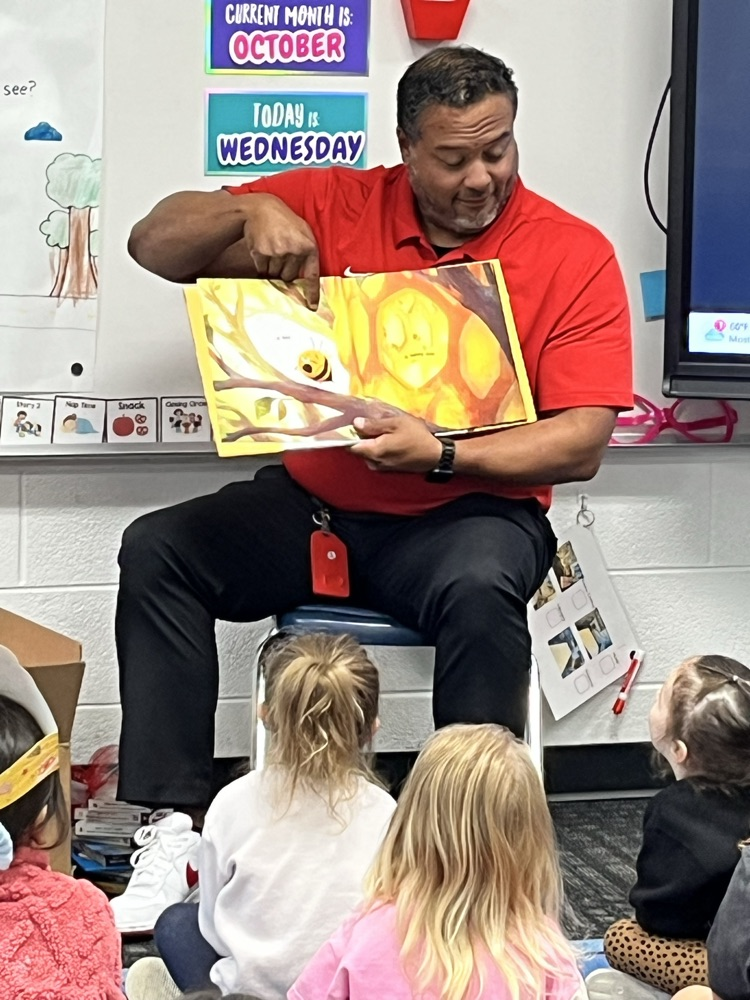 Deputy Superintendent Nick Sun showing a book illustration to the students