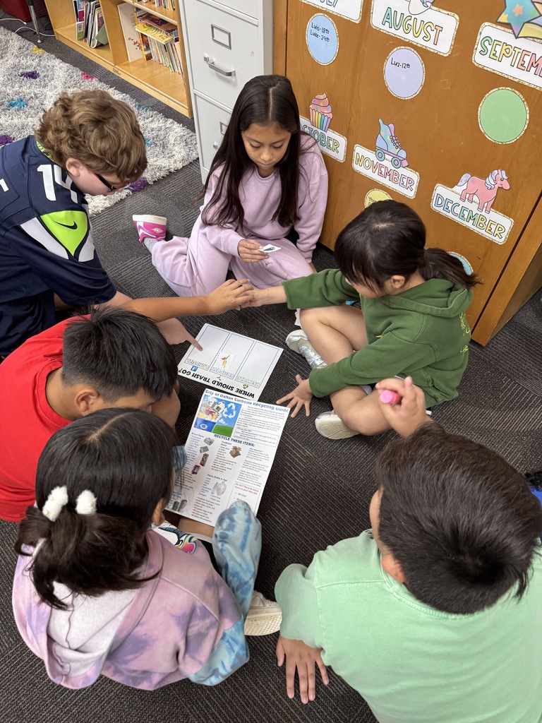 Students using recycling guides to sort trash