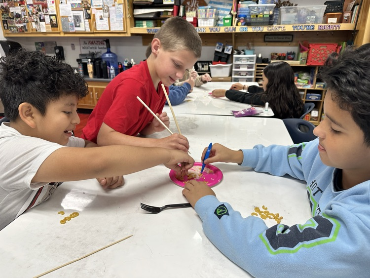 Students trying to pick up food using a fork